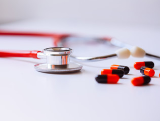 stethoscope for doctor checkup with pills on medical laboratory table