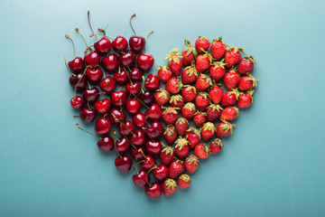 Fresh cherries and strawberries shaped like heart, top view