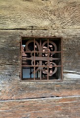 a small old window on a wooden wall