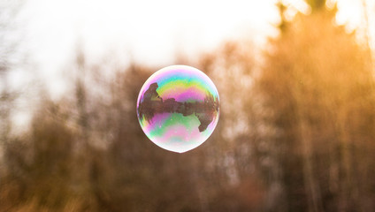 Seifenblase mit Haus spiegelung. Soap bubble in the air with nature defocused.