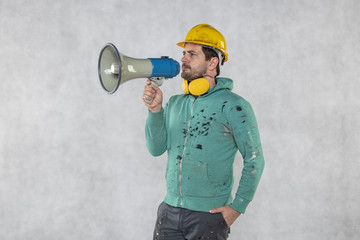 the construction worker holds a megaphone in his hands, the concept of issuing orders