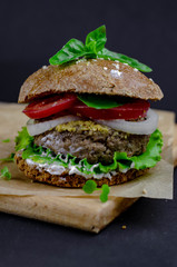 burger with homemade whole grain bun, beef cutlet, tomatoes, onion, salad, mozzarella, yogurt and mustard. healthy food. proper nutrition fast food