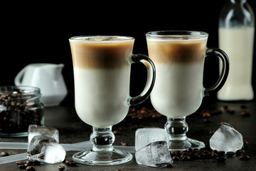 Ice latte or Iced coffee with milk and ice cubes in a glass beaker against a dark background. refreshing drink. summer drink.