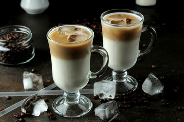 Ice latte or Iced coffee with milk and ice cubes in a glass beaker against a dark background. refreshing drink. summer drink.