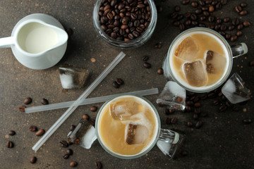 Ice latte or Iced coffee with milk and ice cubes in a glass beaker against a dark background. refreshing drink. summer drink. top view