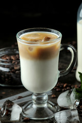 Ice latte or Iced coffee with milk and ice cubes in a glass beaker against a dark background. refreshing drink. summer drink.