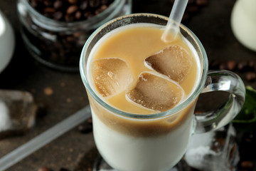 Ice latte or Iced coffee with milk and ice cubes in a glass beaker against a dark background. refreshing drink. summer drink.