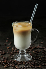 Ice latte or Iced coffee with milk and ice cubes in a glass beaker against a dark background. refreshing drink. summer drink.