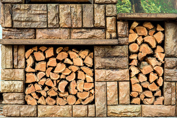 brown stone grill with storage space for spare firewood.