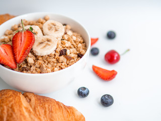 Summer breakfast oatmeal with berries and croissants. Closeup shot on white background
