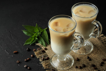 Ice latte or Iced coffee with milk and ice cubes in a glass beaker against a dark background. refreshing drink. summer drink.