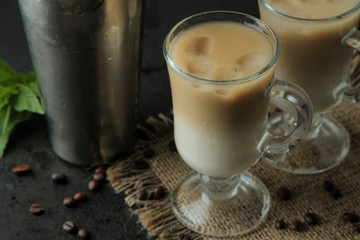 Ice latte or Iced coffee with milk and ice cubes in a glass beaker against a dark background. refreshing drink. summer drink.