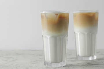 Ice latte or Iced coffee with milk and ice cubes in a glass beaker on a light background. refreshing drink. summer drink.