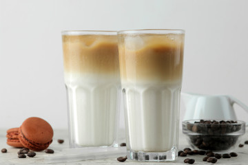 Ice latte or Iced coffee with milk and ice cubes in a glass beaker on a light background. refreshing drink. summer drink.