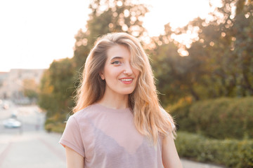 Beautiful young woman walking in the city under sunlight.