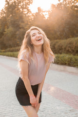 Cheerful young woman walking on the street and laughing