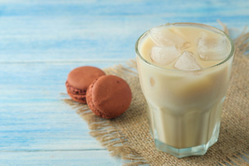 iced coffee with milk and ice cubes in a glass cup on a light blue background. refreshing drink....