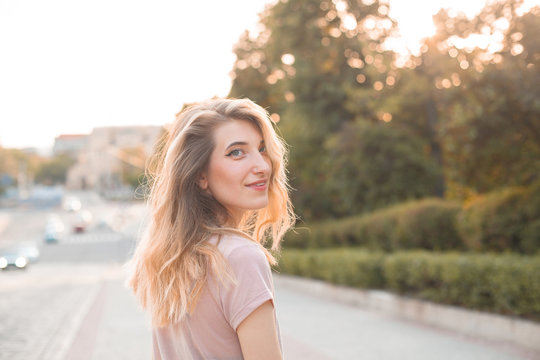 Beautiful young woman walking in the city. Turn around.