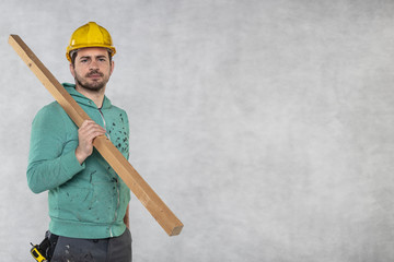 the construction worker holds a piece of board in his hands, the concept of choosing wood for construction