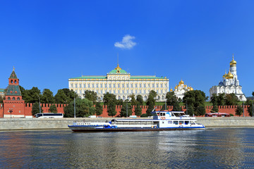 Naklejka premium River tourist ship sails past the Moscow Kremlin on a warm summer day