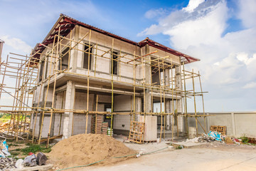construction residential new house in progress at building site with clouds and blue sky