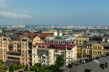 Fototapeta na wymiar Aerial view from St. Sophia Cathedral on buildings of historical center of Kiev. Beautiful Kiev roofs. In background - modern buildings of Kiev. Kiev - capital of Ukraine - motherland of Russia