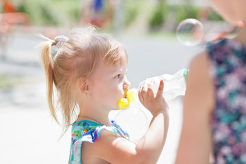 Adorable child baby drinking water from bottle