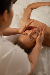 Professional master using special movements during face massage