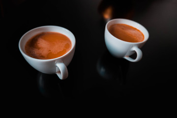 cup of coffee with steam on black background