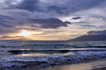 Fototapeta premium A beautiful sunset view of the Hawaiian ocean and its gentle waves seen from Maui.