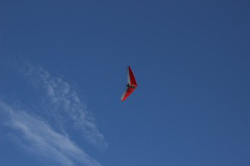 Fototapeta na wymiar The hang-glider flying in the blue clear sky. Summer in Russia.