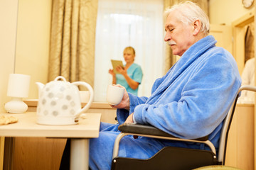 Senior man drinks coffee in assisted living