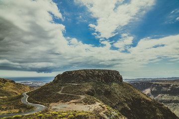 Dusty road horizon with monumental canyon mountain.