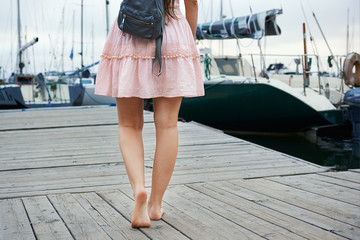 cropped image of a woman going to a wooden pier on a yacht © evafesenuk