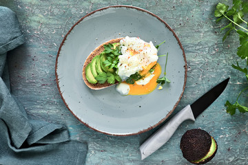 Avocado sandwich with dark bread, sliced avocado and poached egg,