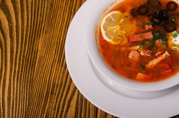 Traditional Ukrainian borsch with sour cream and white beans on a dark background. Red vegetable beetroot soup.