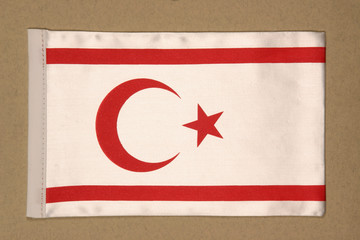 Turkish Republic of Northern Cyprus flag made of white satin fabric, painted with red moon and stars