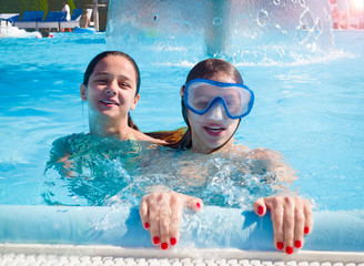 Two happy children playing on the swimming pool in aqua park at the day time. People having fun...