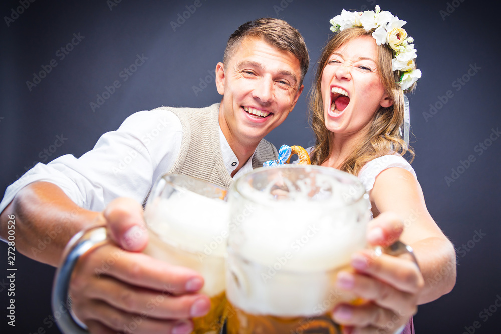 Wall mural  Mann und Frau stoßen mit Maß bier an und lachen auf dem Oktoberfest 