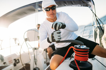 Attractive strong woman sailing with her boat