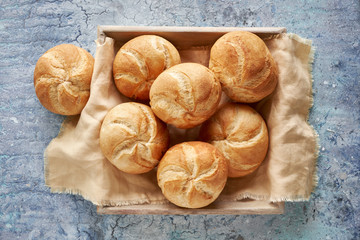 Crusty round bread rolls, known as Kaiser or Vienna rolls on linen towel