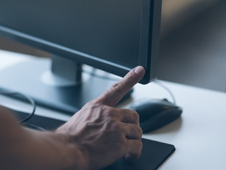 Office worker routine. Cropped shot of man switching computer monitor on. Blurred workplace...