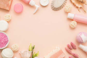 Organic body care products. Flat lay of bath salt, handmade soap, floral and sea decor. Peach background. Round frame copy space.