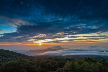 sunrise at Doi Inthanon, Km. 41 view point, mountain view misty morning on top hill around with sea of mist in valley and yellow sun light in the sky background, Chiang Mai, Thailand.