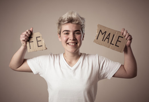 Transgender teenager breaking the word FEMALE into MALE. Gender identity and human rights concept.