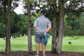 golfer watches his competition warm up