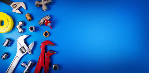 plumbing tools and fittings on blue background with copy space - obrazy, fototapety, plakaty