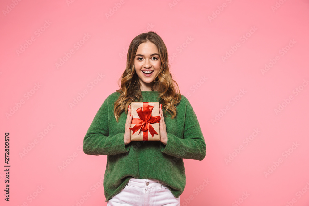 Poster happy blonde woman wearing in green sweater holding gift box