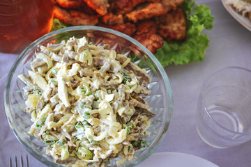 salad of chopped vegetables and meat with mayonnaise in a plate.