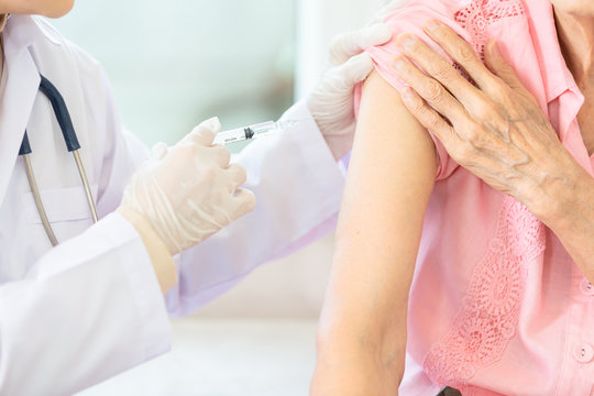 Close Up,asian Female Doctor With Syringe Doing Injection Vaccine,flu,influenza In The Shoulder Of Senior Woman, Nurse Injecting,vaccinating Elderly Patient,vaccination,medicine,health Care Concept